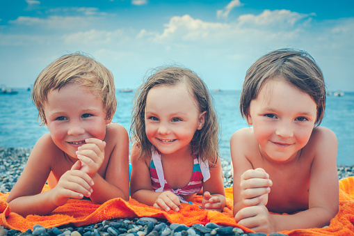 Happy little boys and girl by the sea