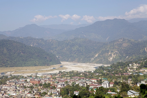 Phuntsholing and Jaigaon town view with Torsa river valley in the background. The two towns are one urban conglomerate at the border between Bhutan, Phuntsholing, and India, Jaigaon.