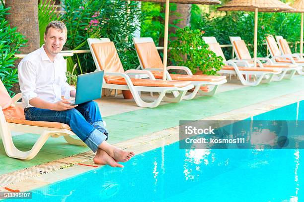 Manager With A Laptop Smiling And Working Stock Photo - Download Image Now - Adult, Adults Only, Barefoot