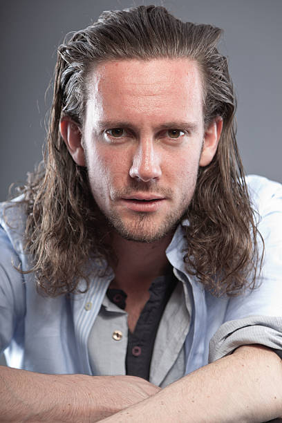 istock Man with long hair and expressive face wearing blue shirt. 513396101