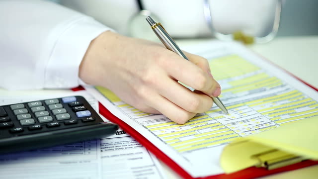 Woman physician filling out papers, calculating patient's health insurance costs