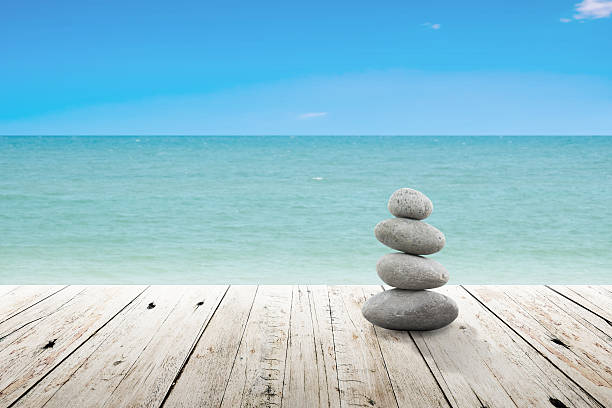 istock Stack of pebble stones at the beach on a wooden. 513415398