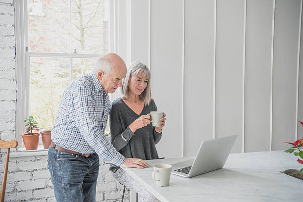 istock Senior couple using laptop, woman holding coffee 513415754