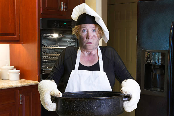 Kitchen disaster with apron and chef hat stock photo