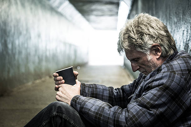 istock Homeless man in subway tunnel begging with paper cup 513416408