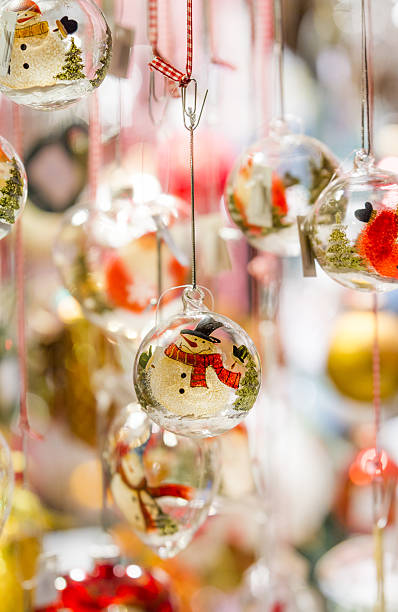 Snowman glass ornaments hanging from a stall at Colmar Christmas market