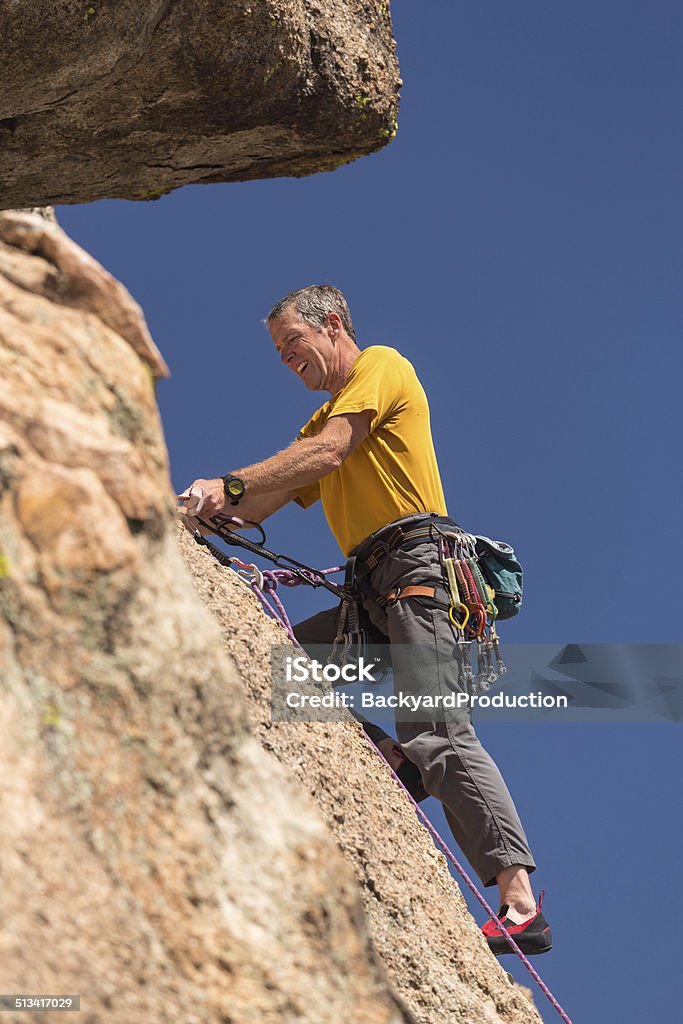 Senior man at top of rock climb in Colorado Senior male climber well equipped with cams and caribiners on Turtle Rocks near Buena Vista Colorado Colorado Stock Photo