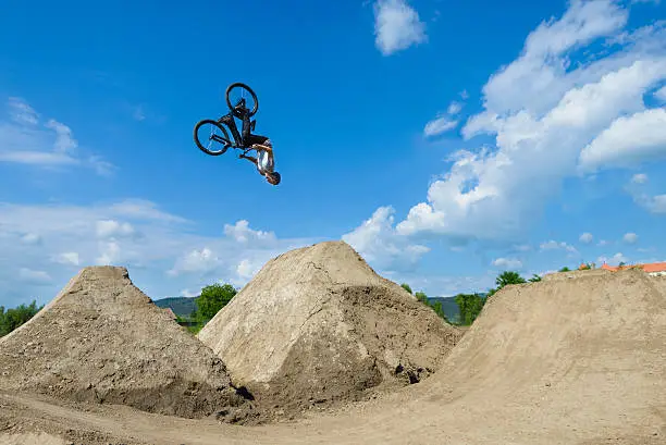 Man does somersaults on bike, summer day