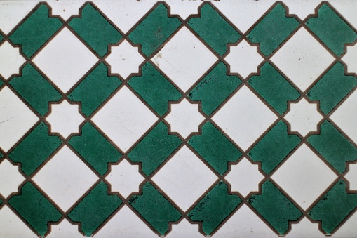 Tile pattern in latticed green stripes on white with star shaped detail.