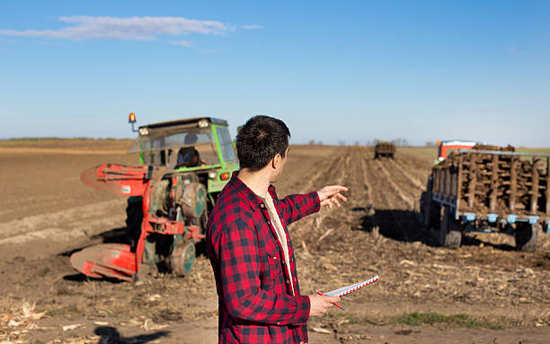 istock Farmer on field with tractors that working 513424906