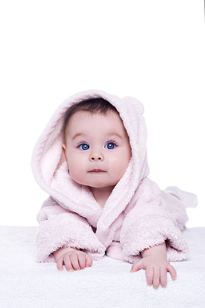 istock cute baby child in pink bathrobe lying down on blanket 513426156