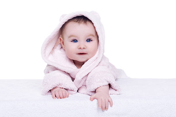 istock cute baby child in pink bathrobe lying down on blanket 513426478