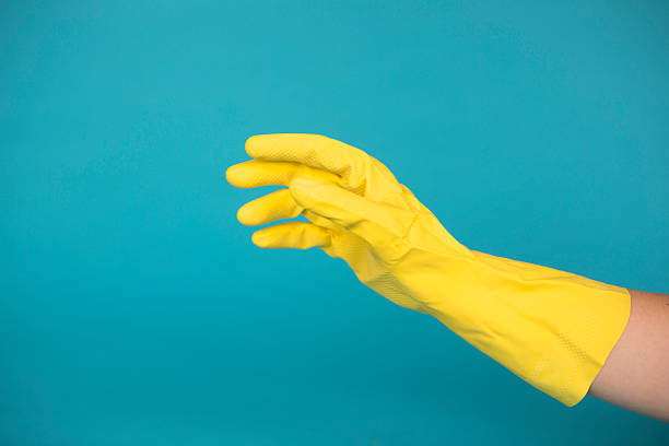 gants en caoutchouc jaune sur fond bleu - protective glove washing up glove cleaning latex photos et images de collection