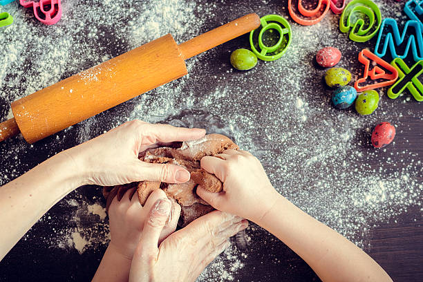 istock Mother teaching daughter how to make dough 513428956