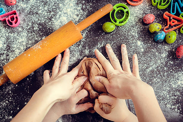 istock Mother teaching daughter how to make dough 513429078
