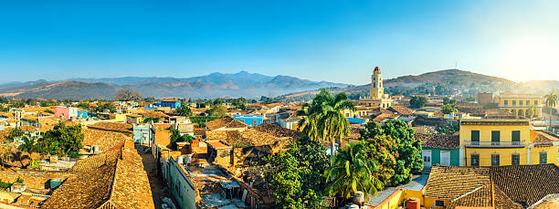 Panoramic view over Trinidad, Cuba Panoramic view over the city of Trinidad, Cuba with mountains in the background and a blue sky. The bell tower belongs to the Iglesia y Convento de San Francisco. trinidad culture stock pictures, royalty-free photos & images