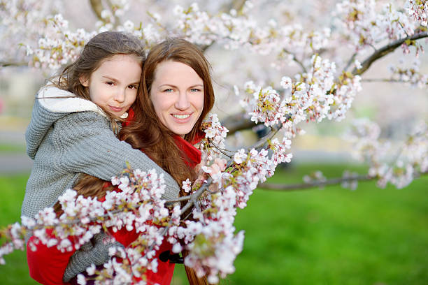 istock Mother and her child in blooming cherry garden 513434314