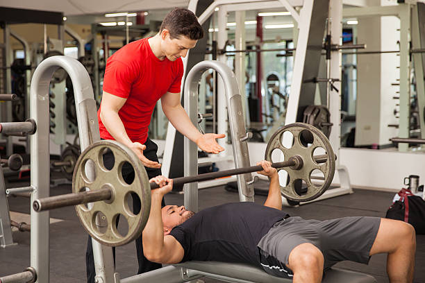 junger mann beobachten die in einem fitnessstudio - weight training weight bench weightlifting men stock-fotos und bilder