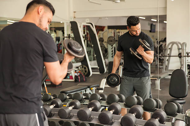 istock Man doing bicep curls in front of a mirror 513434866