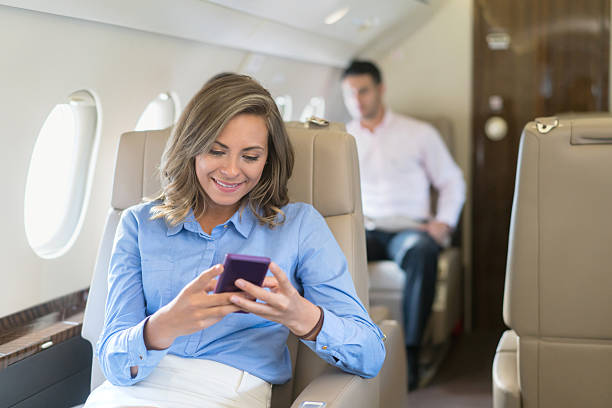 business woman traveling by air and texting - airplane air vehicle business travel passenger imagens e fotografias de stock