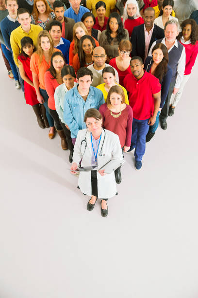 Doctor standing in front of diverse crowd  photography healthcare and medicine studio shot vertical stock pictures, royalty-free photos & images