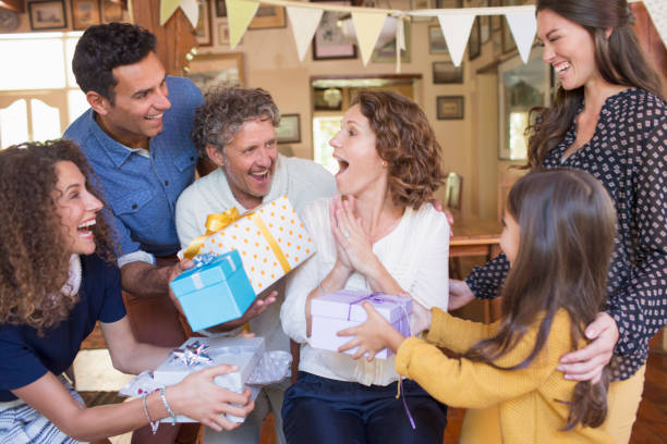 older woman being given gift by family - grandmother giving gift child imagens e fotografias de stock