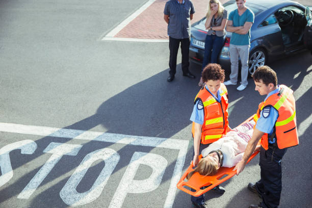 Blurred paramedics in background with injured person lying on stretcher, focus on foreground on a sleeve of ambulance tehnician.