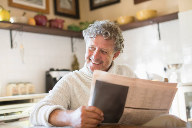 istock Older man reading news paper in kitchen 513438269