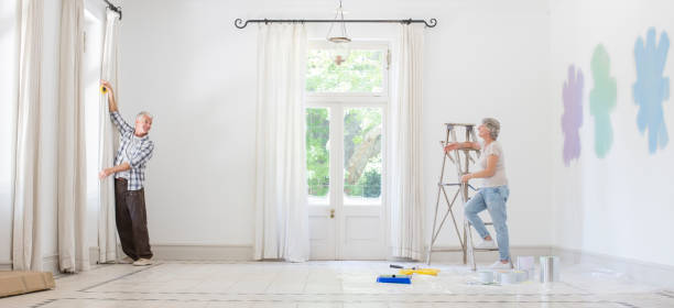 istock Older couple hanging curtains together 513438285