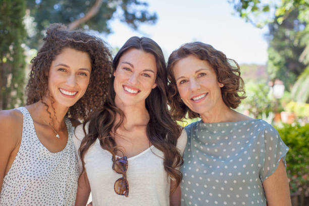 mother and daughters hugging outdoors - vacations two generation family caucasian friendship imagens e fotografias de stock