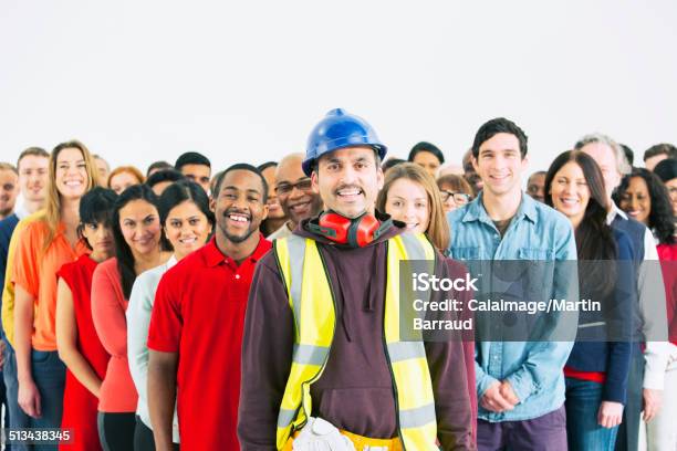 Portrait Of Confident Construction Worker And Crowd Stock Photo - Download Image Now
