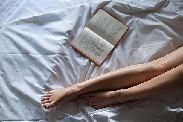 Book by the female legs stock photo