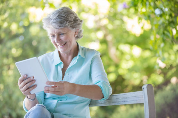 istock Older woman using digital tablet outdoors 513438483