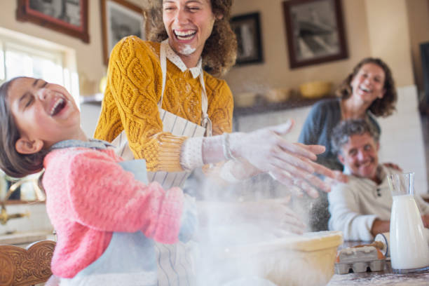 Mother and daughter playing with flour in the kitchen  flour mess stock pictures, royalty-free photos & images