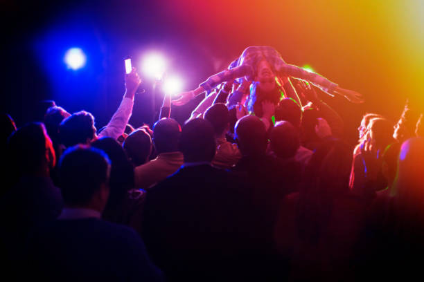 istock Woman crowd surfing at concert 513438521