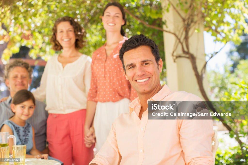 Family gathered around table outdoors  20-24 Years Stock Photo