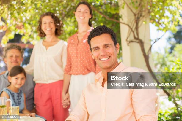 Family Gathered Around Table Outdoors Stock Photo - Download Image Now - 20-24 Years, 30-39 Years, 35-39 Years