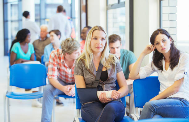 women sitting in hospital waiting room - waiting imagens e fotografias de stock