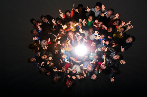 A group of different people stand in a circle isolated on a white background. A social event or public meeting with an empty stage for a performance. 3D rendering