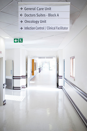 A empty and clean corridor in a hospital in Newcastle upon Tyne, North East England. There are directions to different units and there is no patients or medical professionals in the corridor.