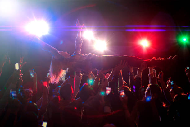 Woman crowd surfing at concert  mosh pit stock pictures, royalty-free photos & images