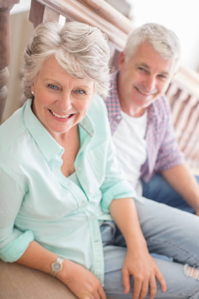 Happy mature couple communicating on a pier at lake. Copy space.