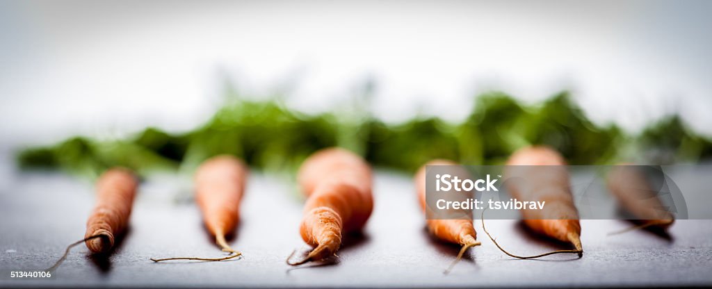 Six Dutch carrots. Six Dutch sweet carrots on bright textured stone background. Extremely shallow depth of field. Baby Carrot Stock Photo