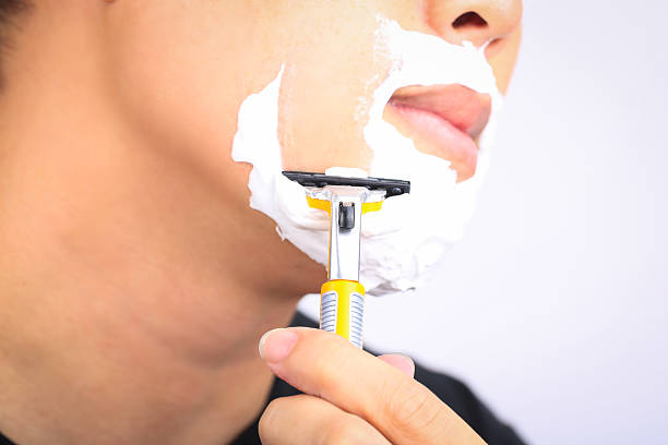 istock Close up young man shaving his face. 513440340