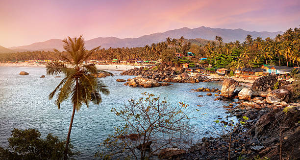 Beautiful view of sunset beach in Goa Beautiful panoramic view of tropical sunset beach with bungalow and coconut palm trees at Palolem in Goa, India palolem beach stock pictures, royalty-free photos & images
