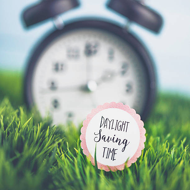 istock Clock in grass with reminder for Daylight Savings Time 513443280