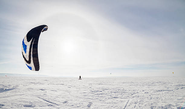 istock Kiteboarder with blue kite on the snow 513443747