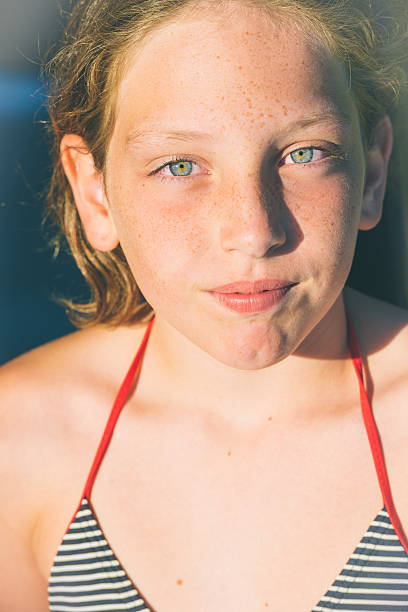 A lovely brunette woman with striking blue eyes thinking about something, looking serene.