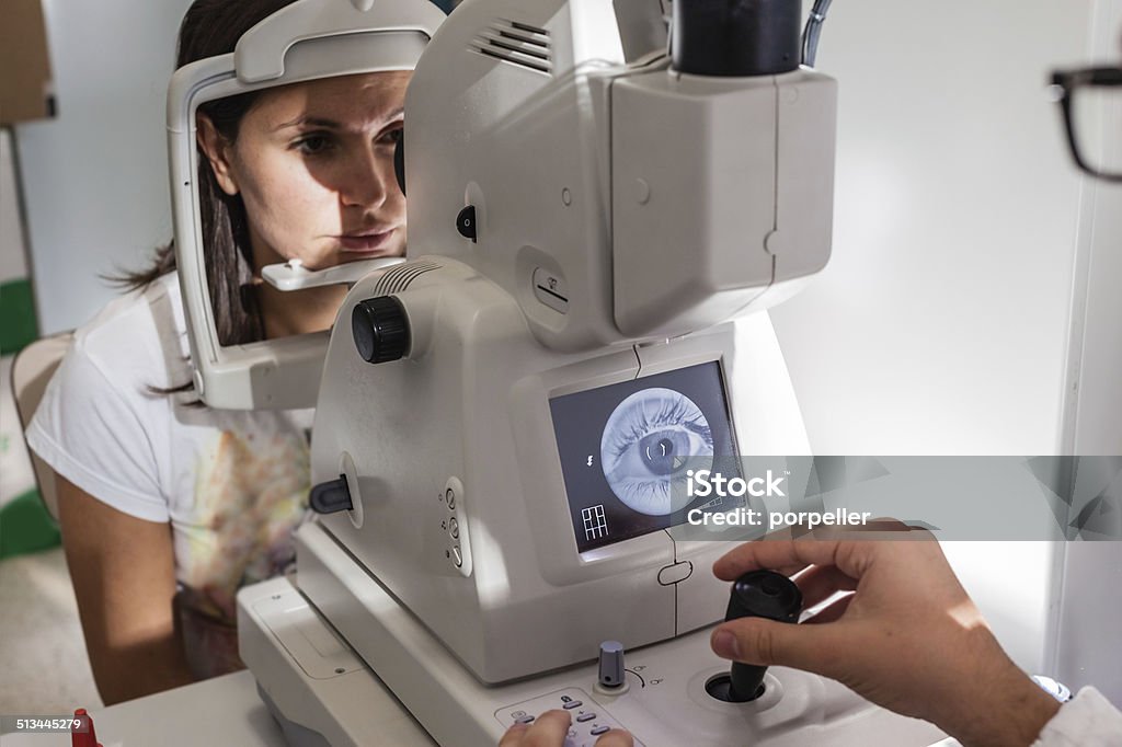 Retinal exam a young ophthalmologist using a non-mydriatic retinal camera on a young girl Medical Exam Stock Photo