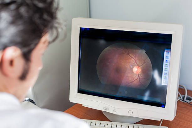 Retina a young ophthalmologist looking at a retina scan in a computer monitor cornea photos stock pictures, royalty-free photos & images